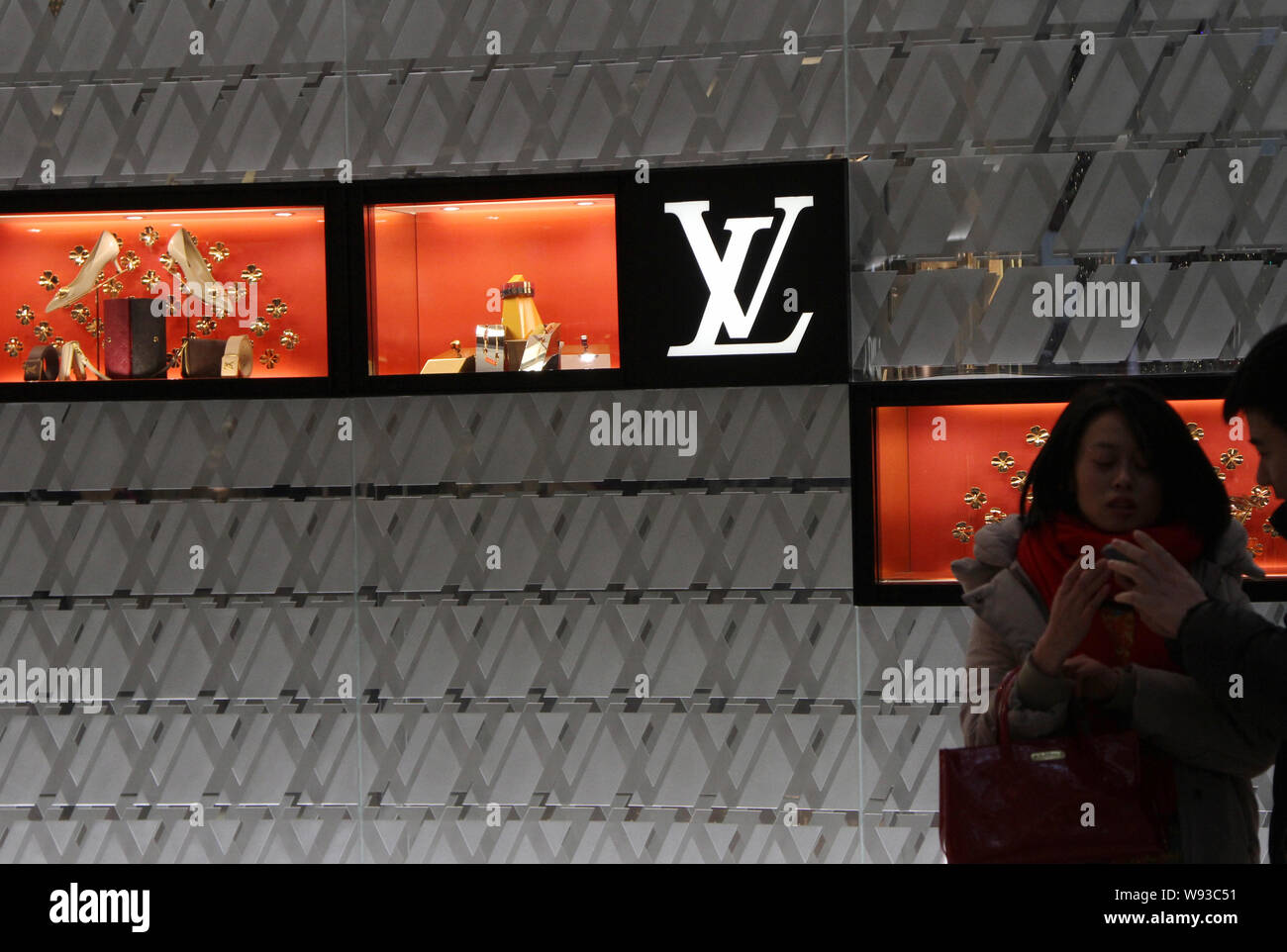 ------ Chinesische Kunden sprechen vor einer LVMH Store in Shanghai, China, 1. Januar 2013. Bekannte Marken mit auffälligen Logos, wie LVMH, Er Stockfoto