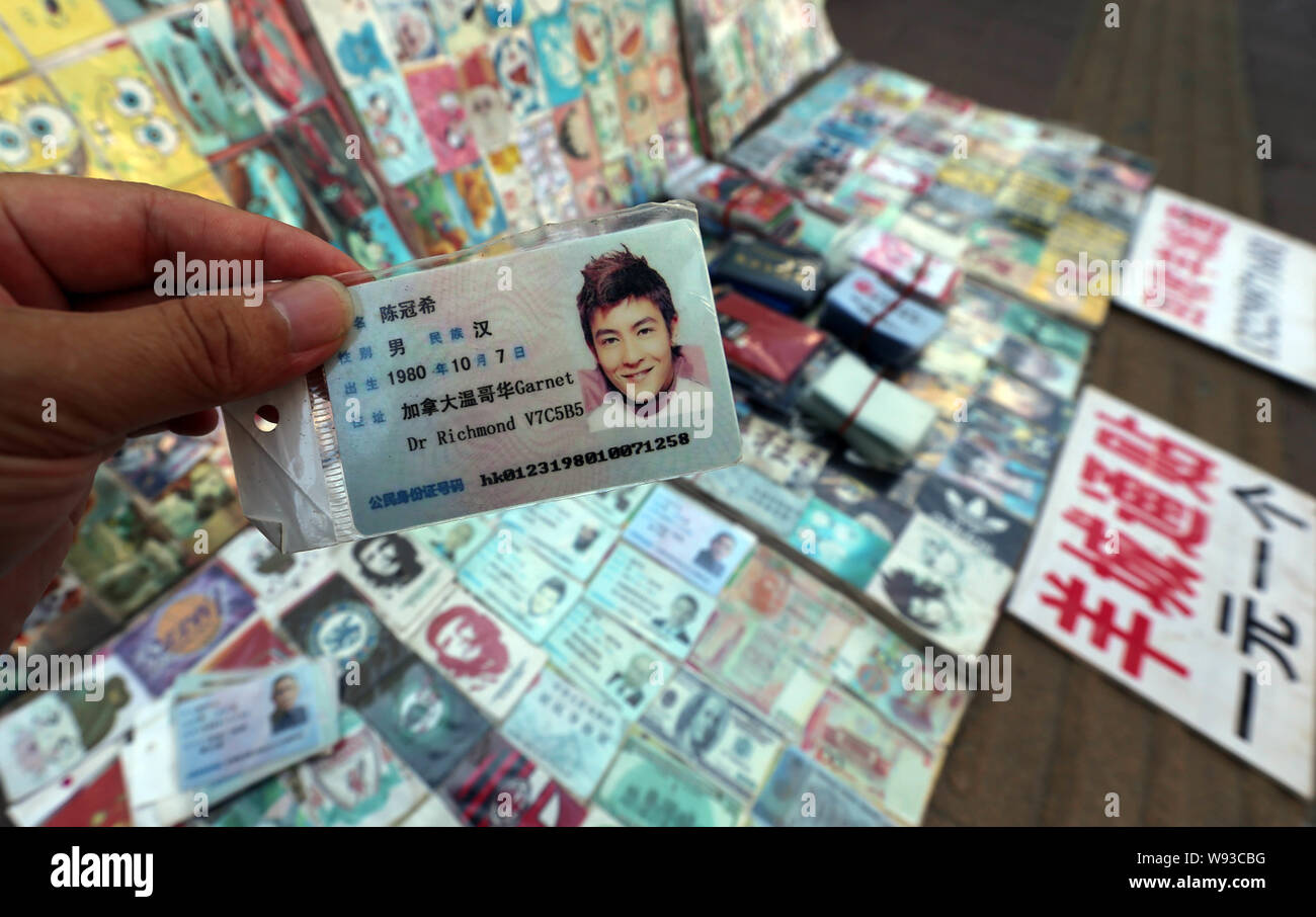 Ein Mann zeigt eine gefälschte Chinesischen ID-Karte von Hongkong Sänger und Schauspieler Edison Chen zum Verkauf an einen Stand auf einer Straße in Guangzhou City, South China Guangdong Stockfoto