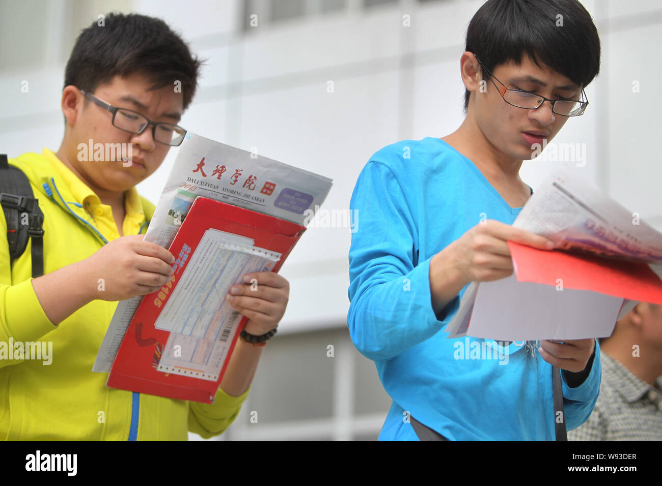 ---- Zwei chinesische Studenten, beide kurzsichtig und Tragen einer Brille, Zeitungen lesen bei Dali Universität in Dali City, im Südwesten von China Yunnan provi Stockfoto