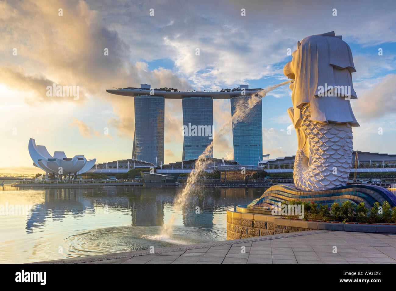 Singapur, Singapur - Juni 9, 2019: Sonnenaufgang an der Marina in Singapur mit der ikonischen Gebäude, Merlion Stockfoto