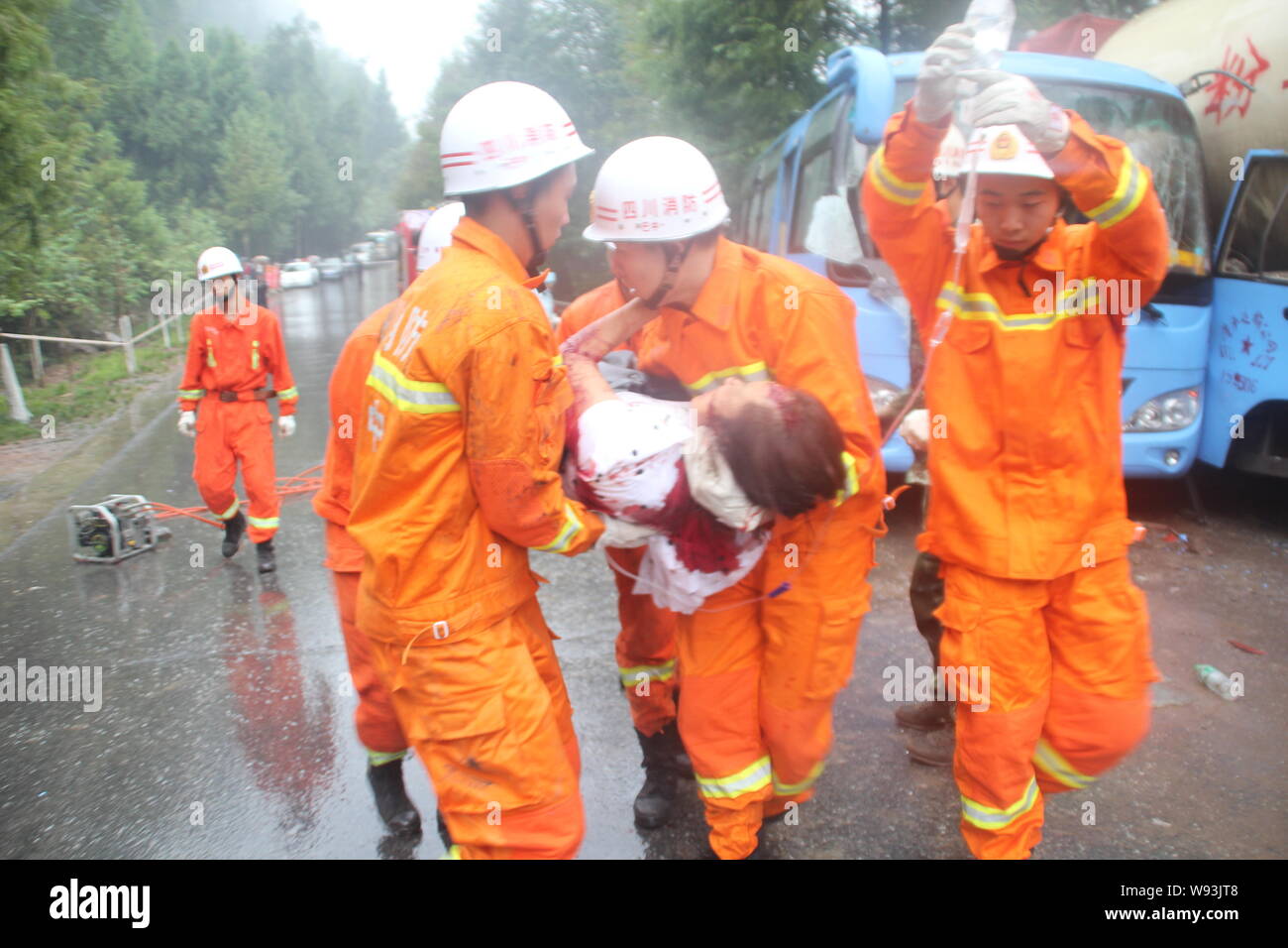 Feuerwehrmänner tragen einen verletzten Fluggast nach einem Tankwagen mit einem Bus auf einer Autobahn in der Stadt Bazhong Shuiningsi zusammenstieß, Stadt, im Südwesten von China Sichu Stockfoto