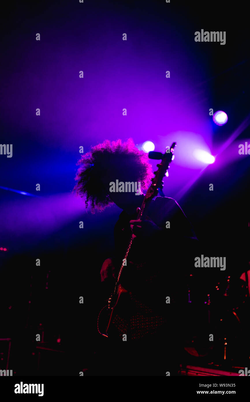 Gitarrist in der Mitte von einem Konzert eine Gitarre solo mit Leuchten hinter Stockfoto