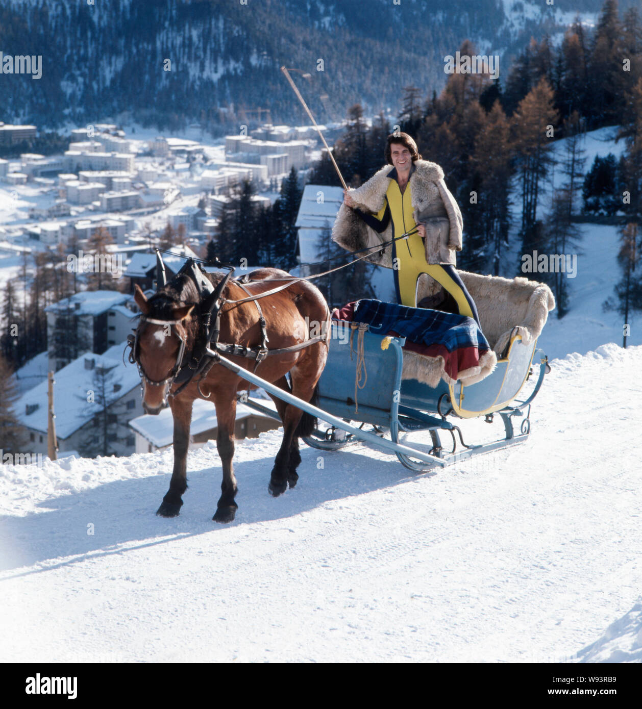 Der deutsche Sänger, Moderator, Songwriter und Gitarrist Peter Rubin bei einem Fotoshooting in den Bergen im Schnee auf einem Schlitten, Anfang der 1970er Jahre. Die deutsche Sängerin, Moderatorin, Songwriter und Gitarrist Peter Rubin bei einem Shooting in den Bergen im Schnee auf einem Schlitten, in den frühen 1970er Jahren. Stockfoto