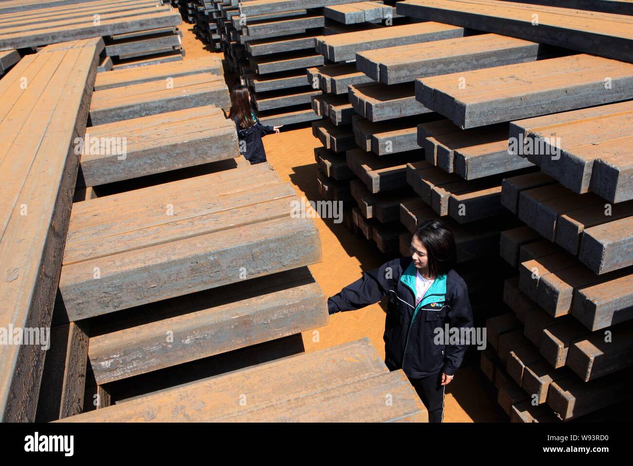 Ein weiblicher chinesischer Arbeiter untersucht einen Stapel von Rohstahl im Ausland Ganyu Ganyu Hafen in Grafschaft zu geliefert werden, East China Jiangsu Provinz, 18 Sept Stockfoto