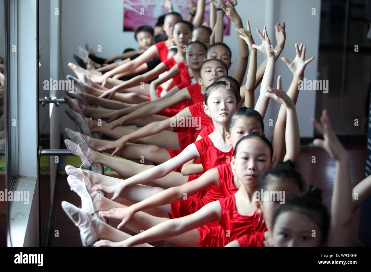 Junge chinesische Mädchen ihren Körper und ihre Beine auf einem Ballet barre Stretch Ballett tanzen in den Sommerferien an einer Schule in Dongxiaon zu erfahren Stockfoto