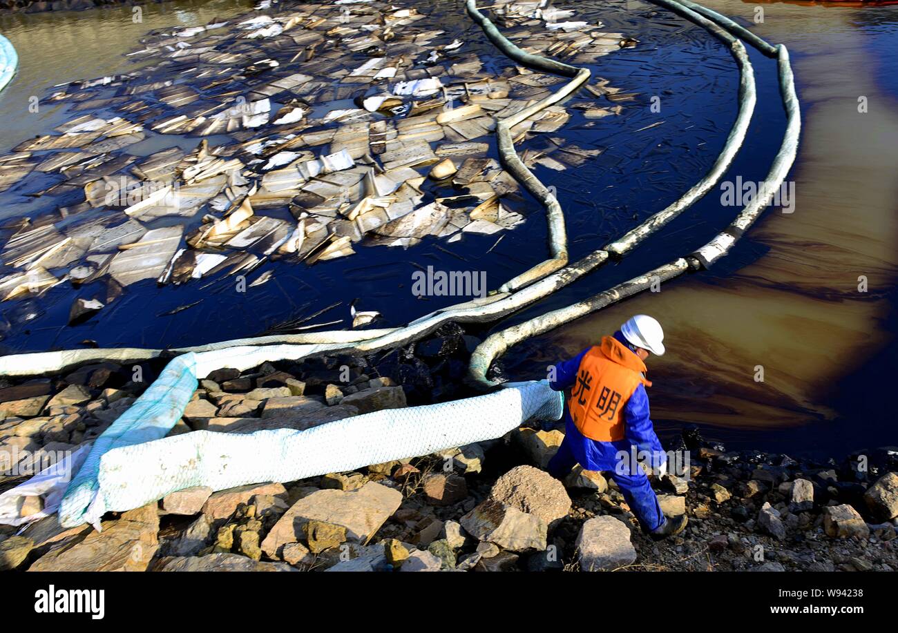 Ein chinesischer Arbeiter bereitet Ölsperren um ausgelaufenes Öl zu reinigen Nach dem Öl pipeline Explosion im Bezirk Huangdao, Qingdao Stadt, East China Shandong p Stockfoto Ein chinesischer Arbeiter bereitet Ölsperren um ausgelaufenes Öl zu reinigen Nach dem Öl pipeline Explosion im Bezirk Huangdao, Qingdao Stadt, East China Shandong p Stockfoto