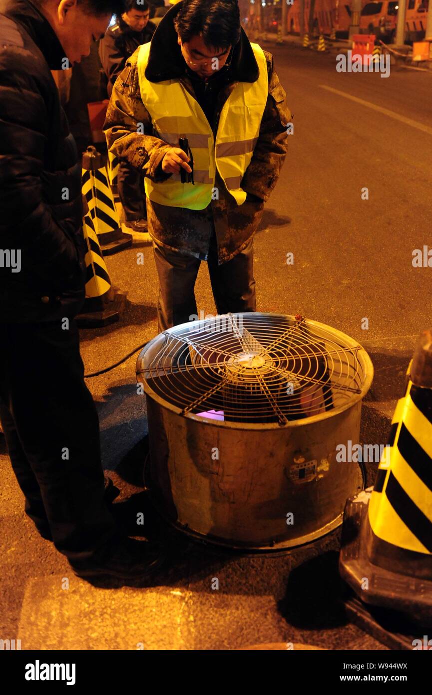 Die Angestellten versuchen, die Lage der undichten Rohr unter Jinanqiao, Shijingshan Distrikt in Peking, China, 13. Januar 2013 zu bestimmen. Die Erwärmung deckt ab Stockfoto