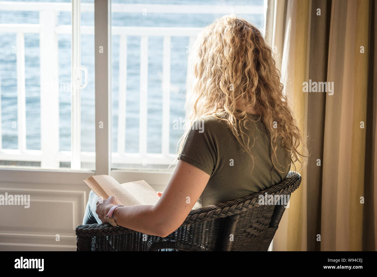 Blonde Frau mit einem Buch in der Sonne Stockfoto