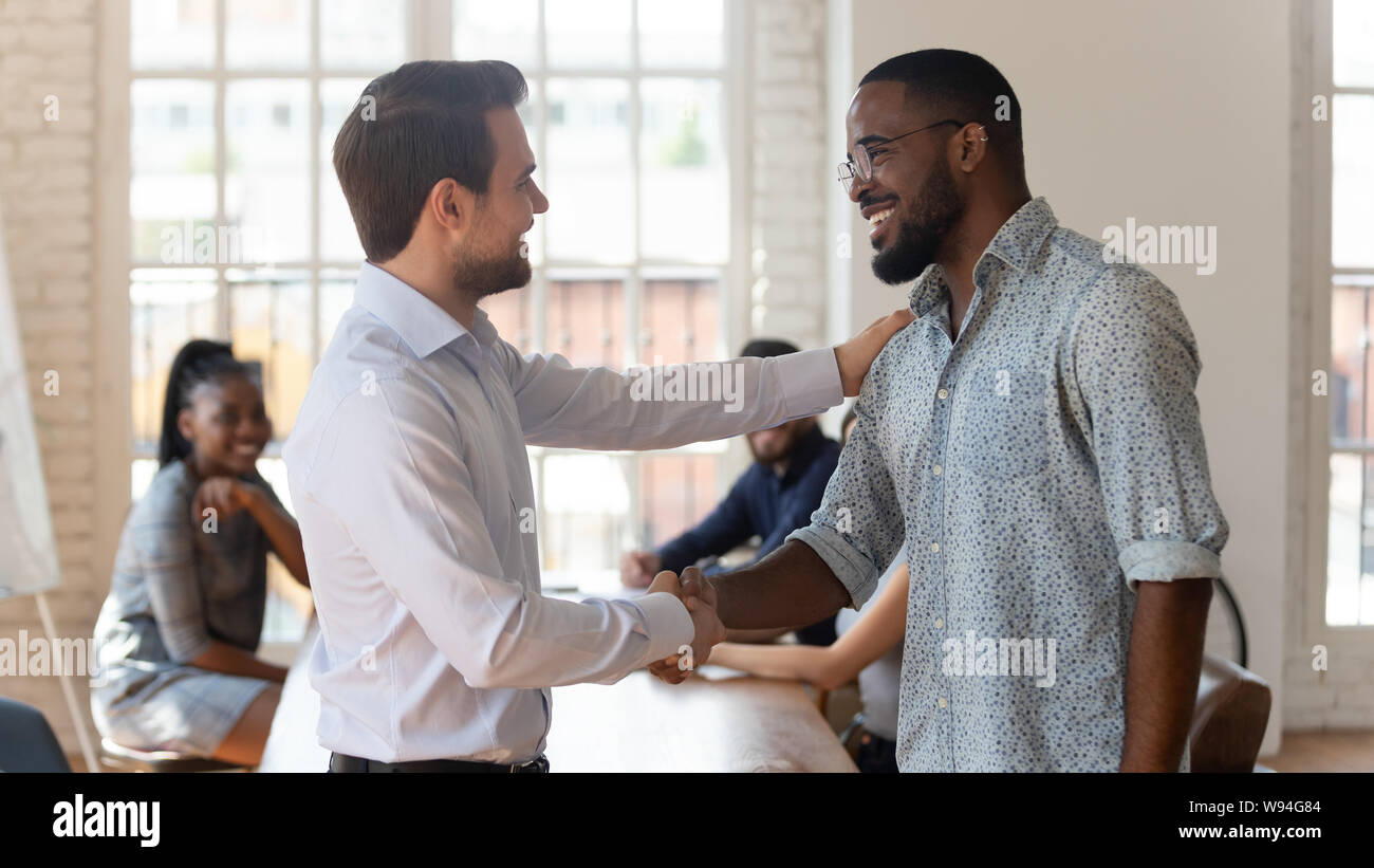 Gerne schwarze männliche Mitarbeiter belohnt Handshake stolz weiß Chef Stockfoto