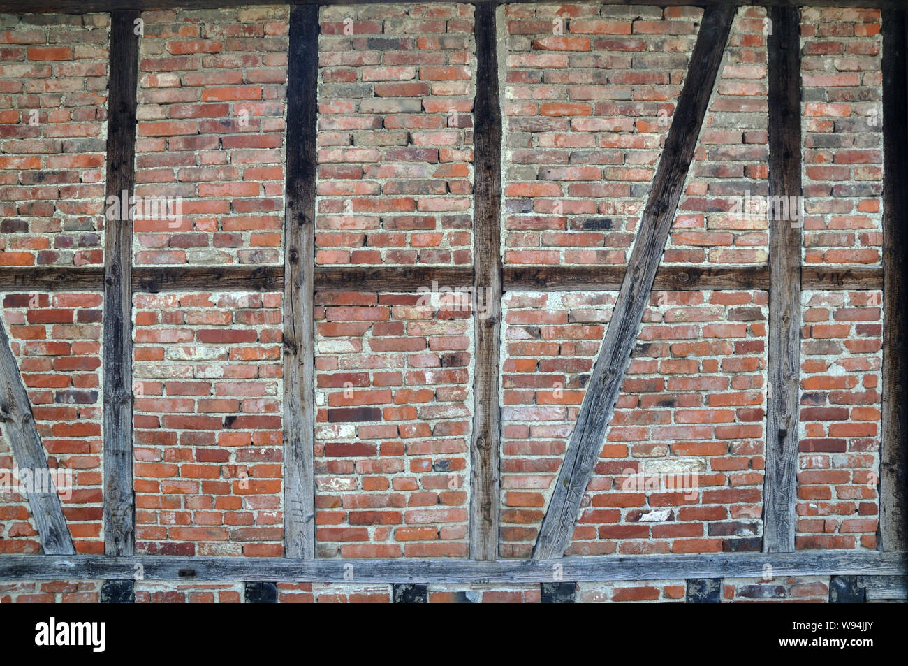 Holzplatten mit Backsteinen auf Holz gefüllt - gestaltete Fassade eines alten deutschen Bauernhaus Stockfoto