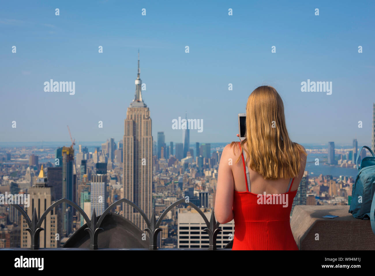 Touristische New York, Rückansicht eines weiblichen Tourist, der ein Foto von Midtown Manhattan von der Aussichtsplattform Rockefeller Center, New York City, USA Stockfoto