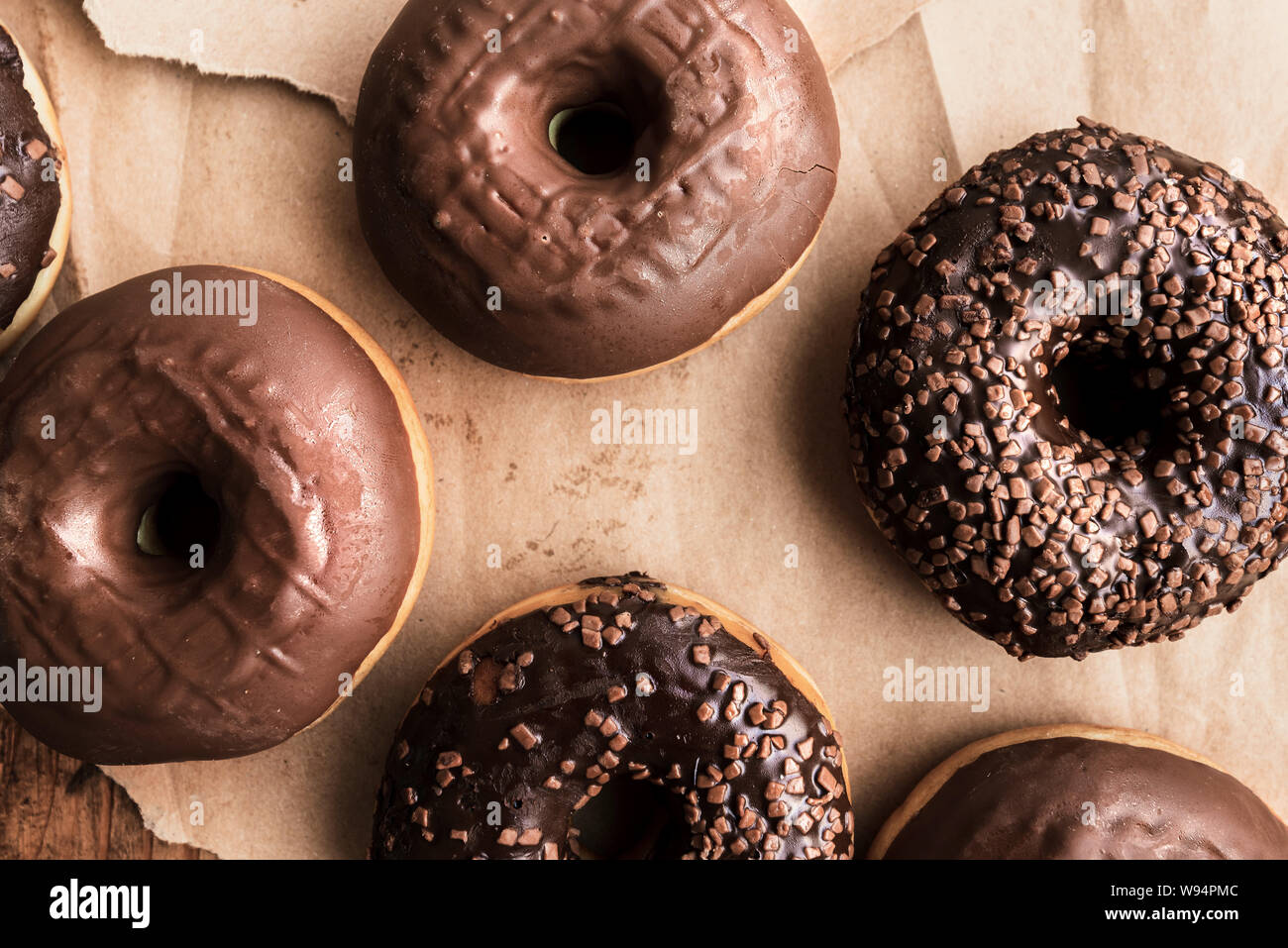 Leckere Schokolade Donuts mit Sahne und Krümel auf rustikalen Holztisch direkt von oben gesehen Stockfoto