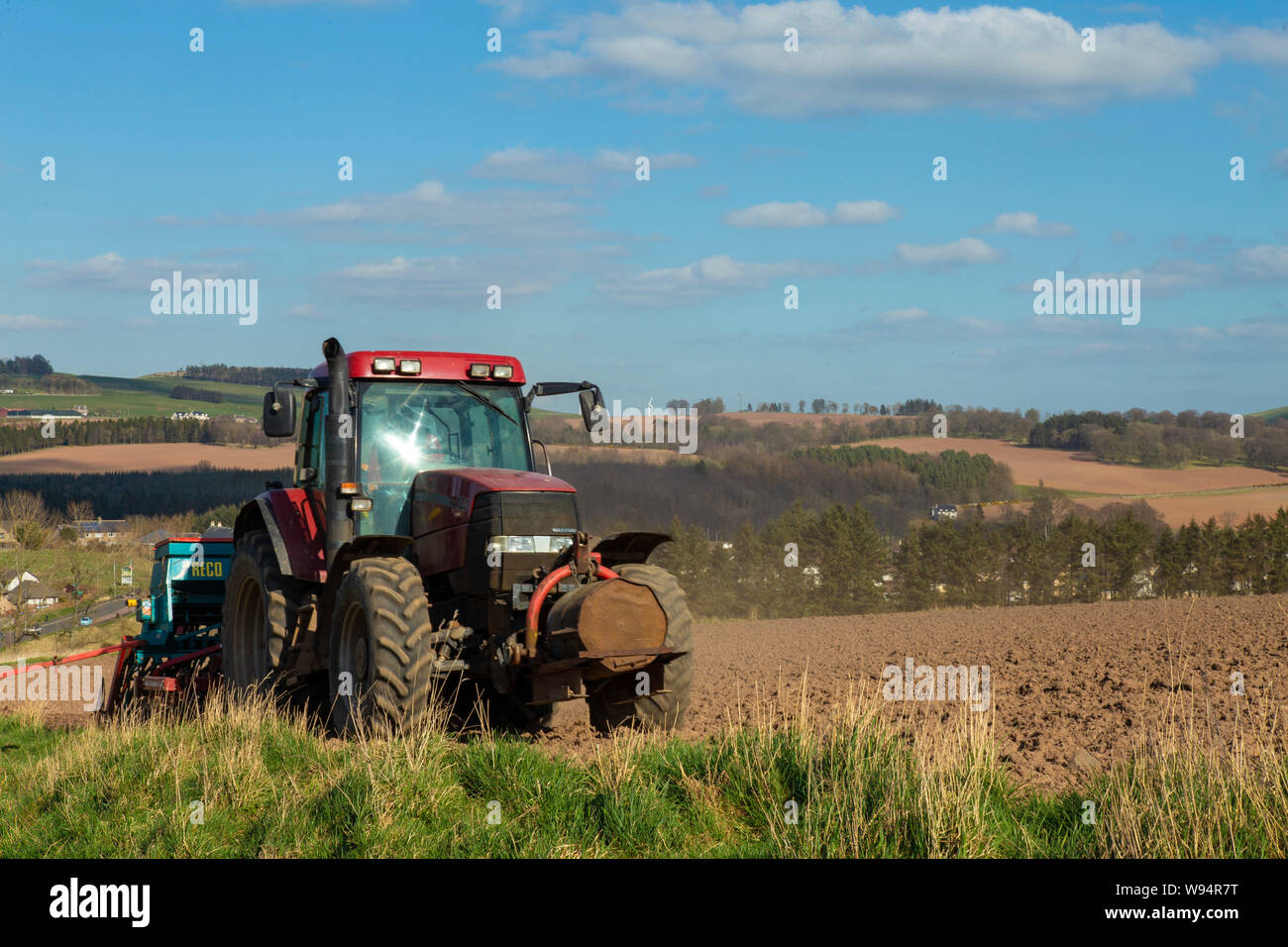 Rote Traktor auf einem Feld in England Nord im Frühling. Lauder, Schottland Stockfoto