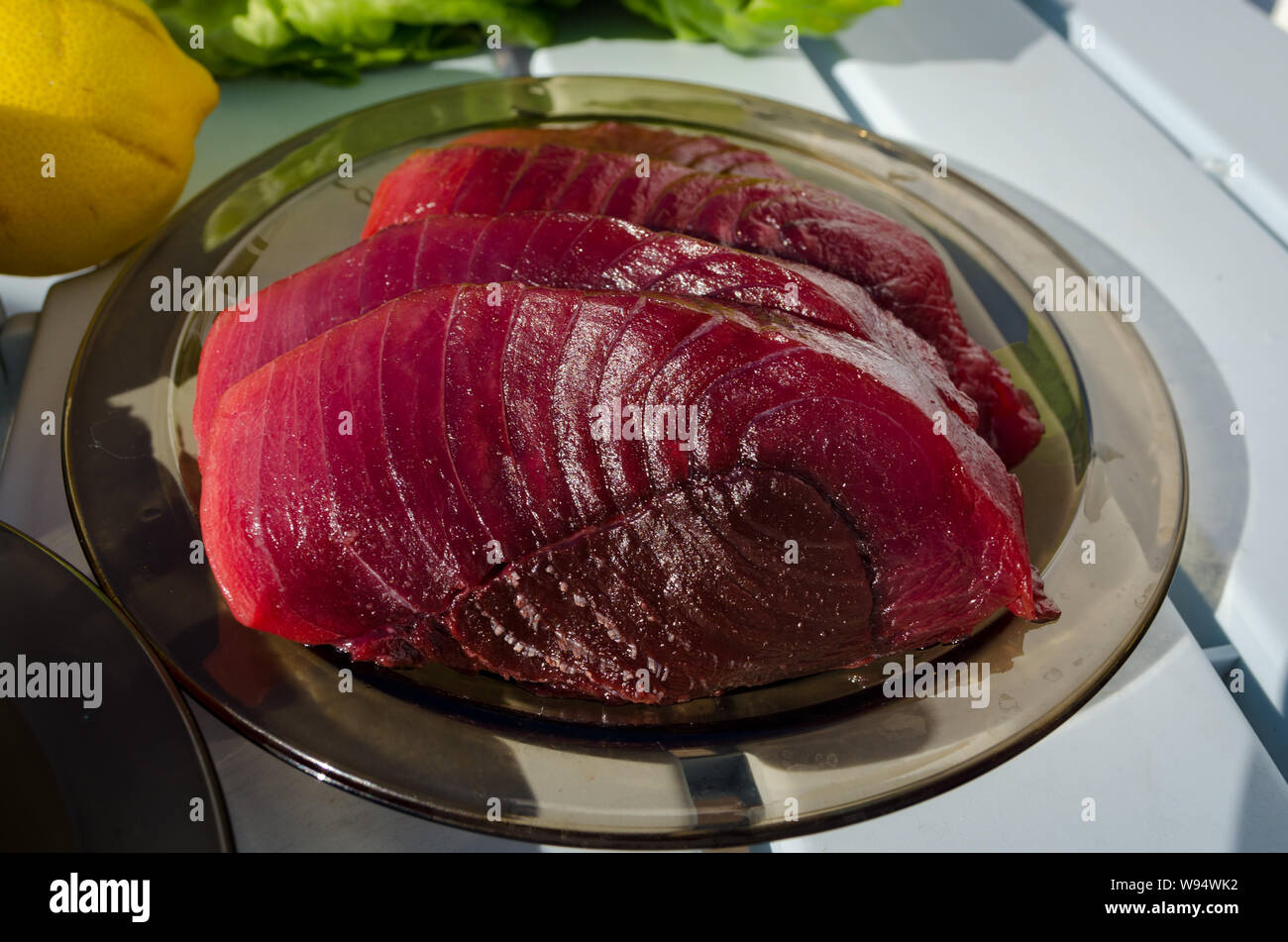 Große Thunfischsteaks auf der Platte vor dem Kochen. Rohe frische Thunfischsteaks Stockfoto
