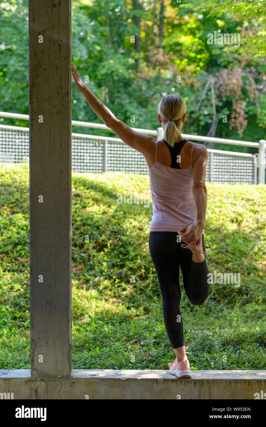 Athletische Frau Tun Aufwärmen Übungen Ihr Bein Muskeln Dehnen Vor Dem Training Und Ein Arm Nach