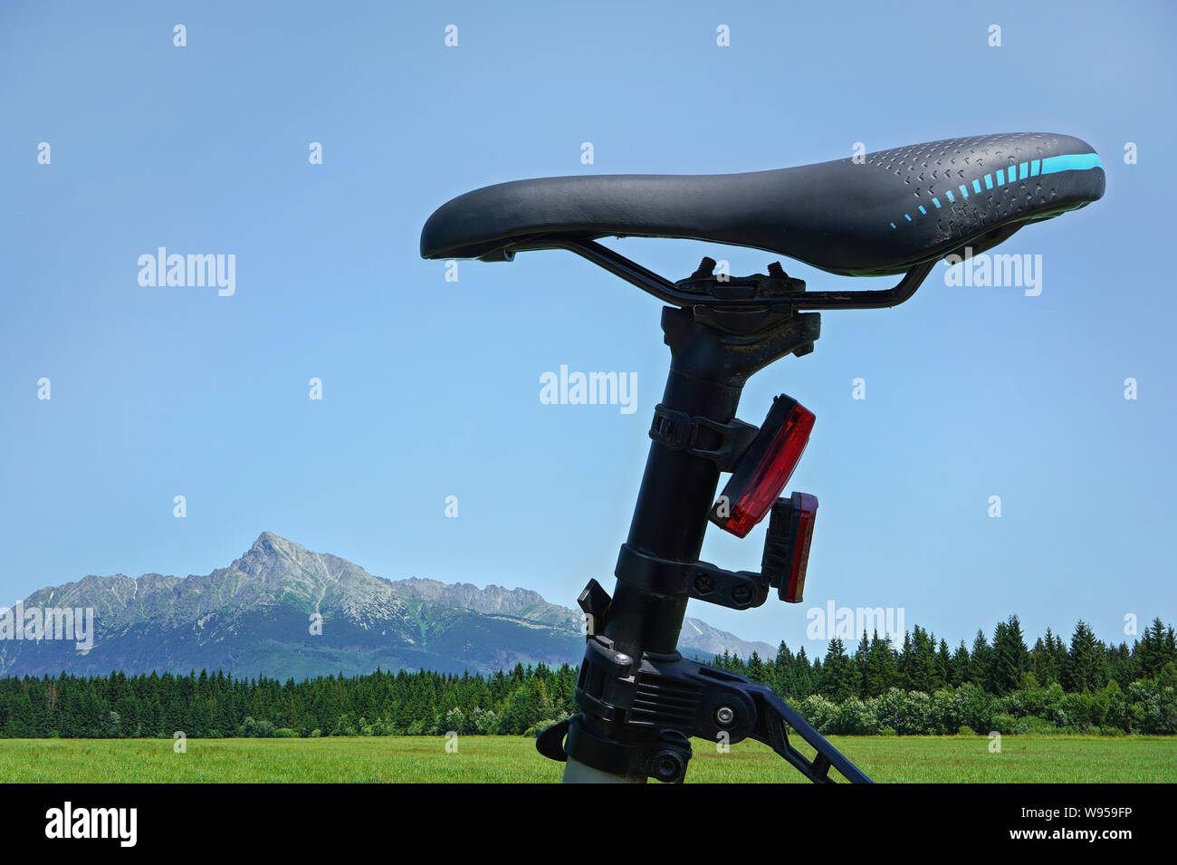 Auf dem Fahrrad Sattel Detail, mit grüner Wiese und Berge Berg Krivan im Hintergrund - Radfahren im Land Konzept Stockfoto