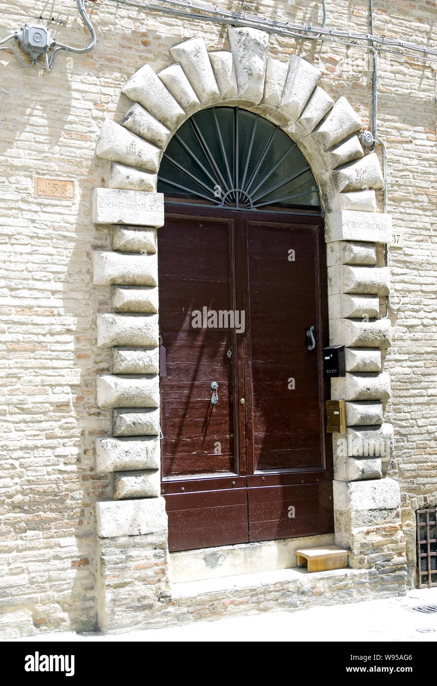 Grand Eingang zu einem kleinen, un-named Palazzo in der kleinen Stadt Recanati, Italien. Quoin - wie Rahmen mit halbrunder Kopf stark abgeschrägten Steine Stockfoto