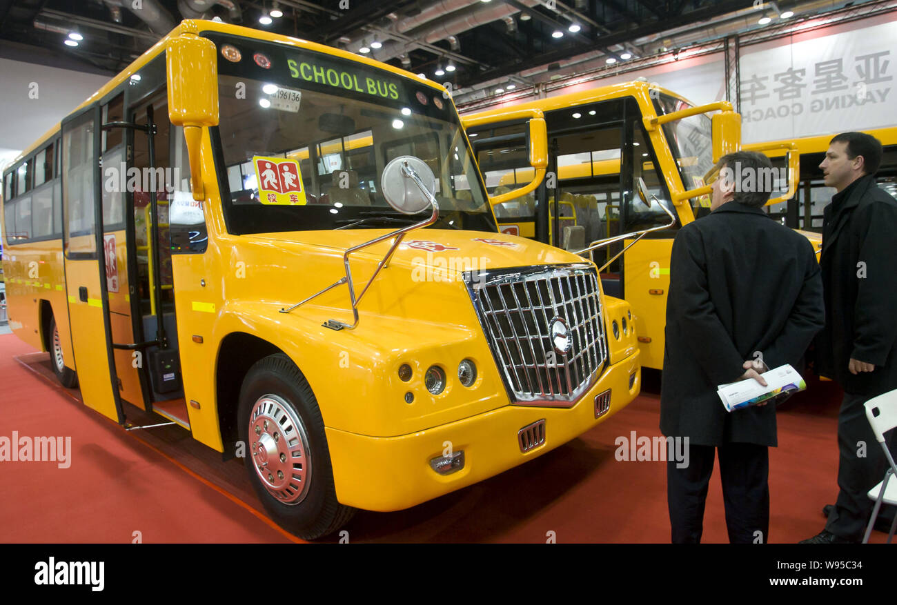 Ausländische Besucher Blick auf Chinesischen Schulbusse während der China International School Bus Ausstellung 2012 in Peking, China, 15. Februar 2012. Th Stockfoto