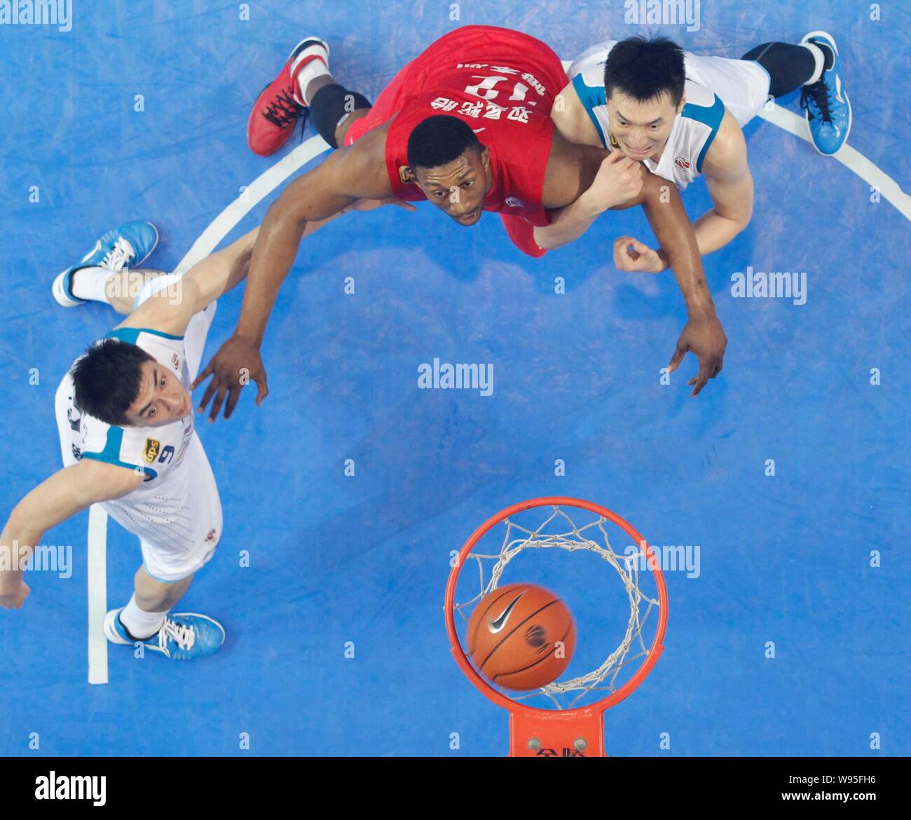 K. Mbenga der Qingdao Adler, Mitte, Herausforderungen Spieler der Fujian Störe in ihrer ersten Runde während der CBA-Saison 2012/2013 in Ji Stockfoto