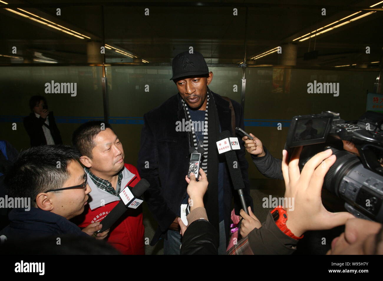 Ehemaliger NBA Spieler K. Mbenga interviewt wird, als er im Qingdao Liuting International Airport in Qingdao Stadt ankommt, East China Provinz Shandong, 1. Stockfoto