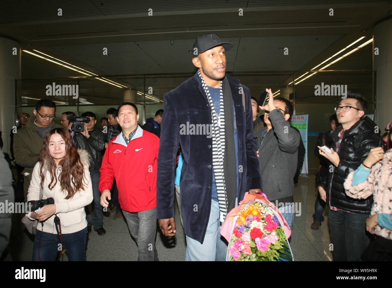 Ehemaliger NBA Spieler K. Mbenga kommt in Qingdao Liuting International Airport in Qingdao Stadt, East China Provinz Shandong, 16. November 2012. Fo Stockfoto