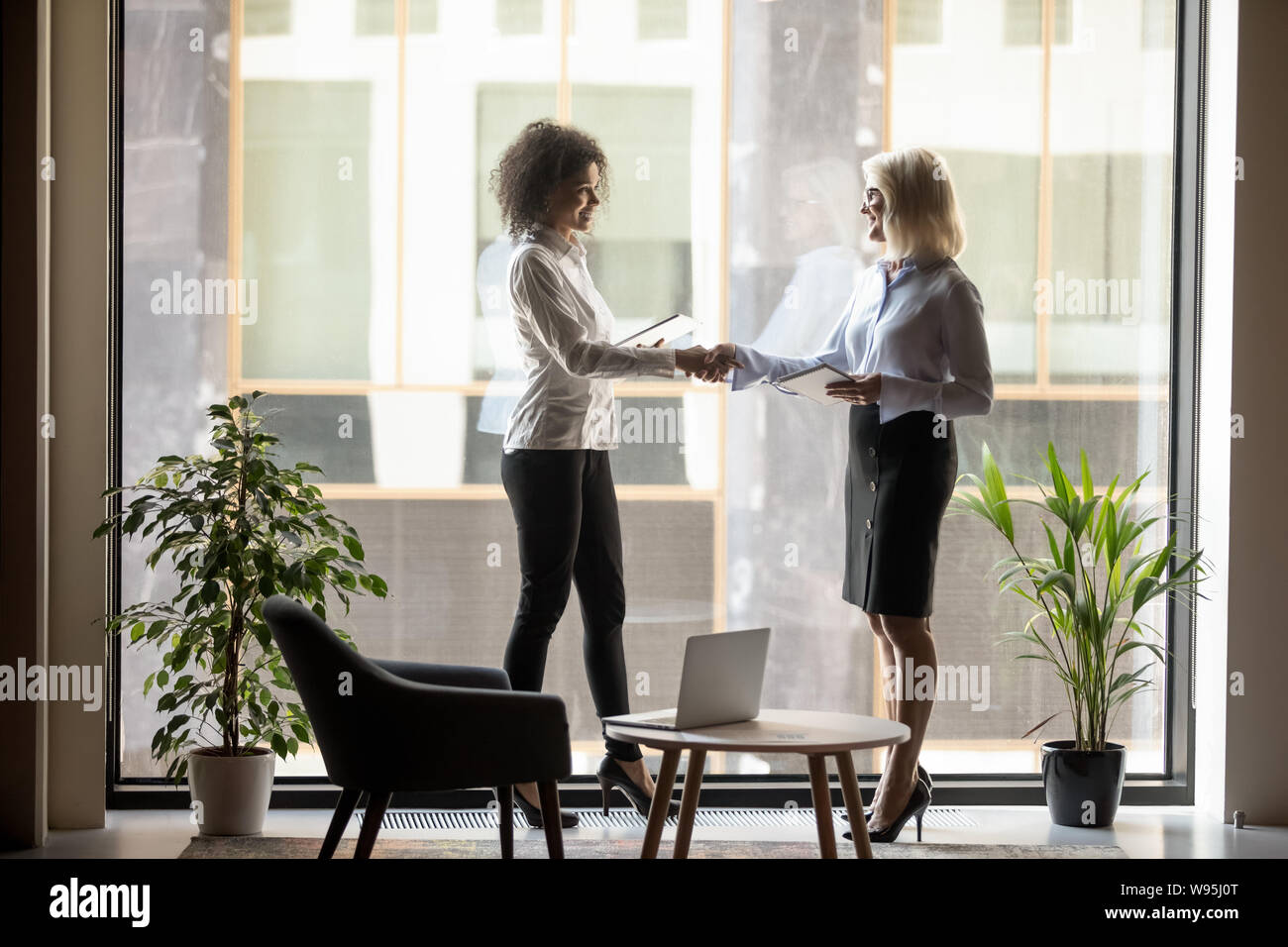 Reife Geschäftsfrau zitternden Hand der afrikanischen amerikanischen Business Partner Stockfoto