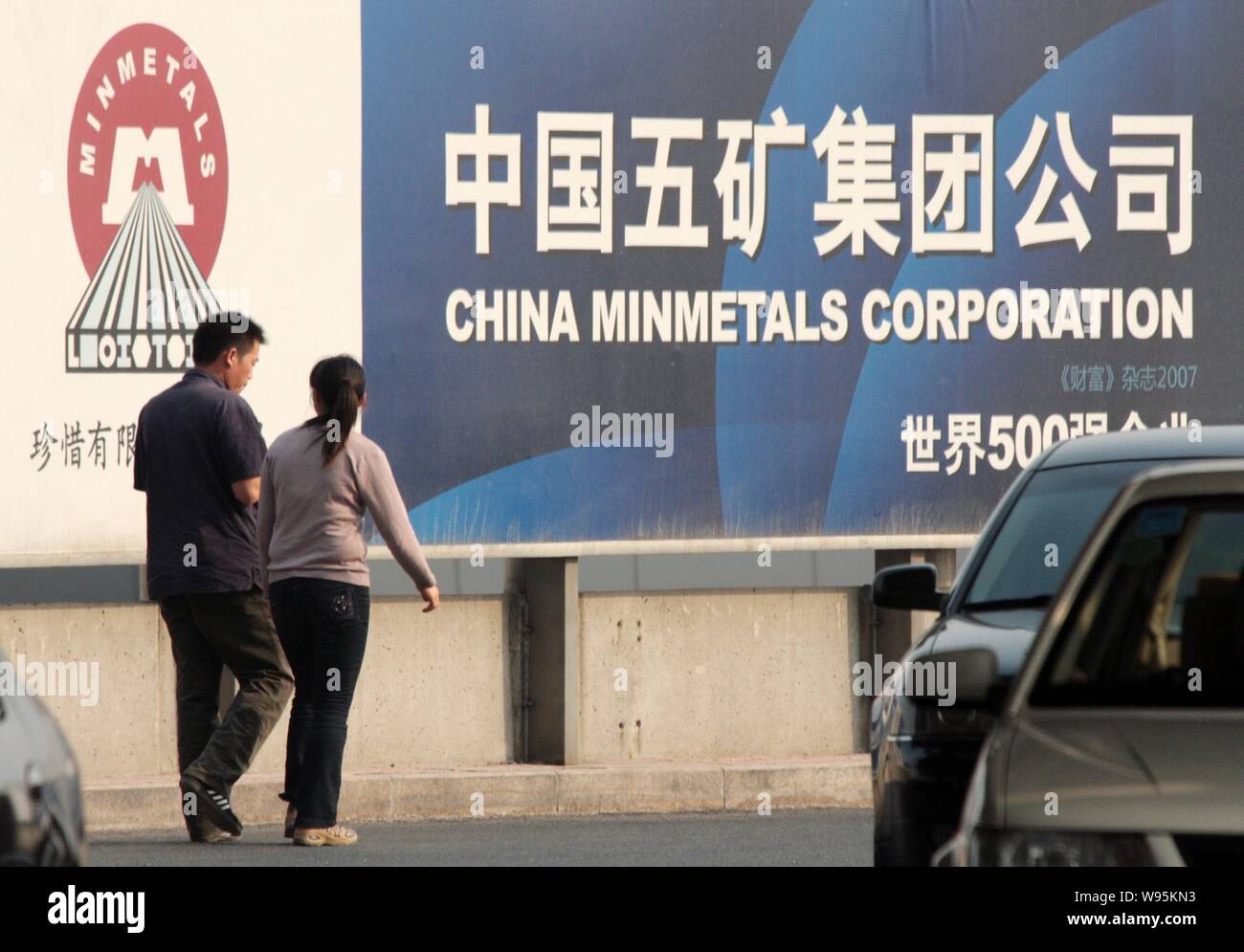 ------ Lokale chinesische Bewohner vorbei an einer Anschlagtafel von China Minmetals Corporation in Peking, China, 6. Mai 2009. China Minmetals Resources hat s Stockfoto