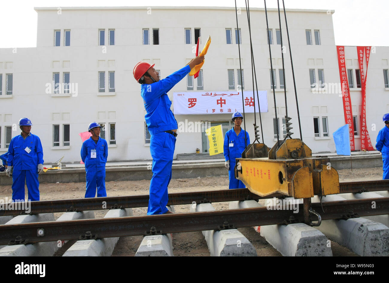 Ein chinesischer Arbeiter leitet ein Kran Titel auf einer Baustelle der Hami-Lop nur Bahn in der Wüste Taklamakan (Taklimakan oder Teklimakan D zu legen Stockfoto