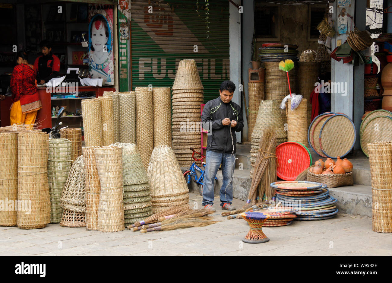 Ein Mann verkauft rattan Produkte außerhalb der Shop im Alten Basar von Pokhara, Nepal Stockfoto