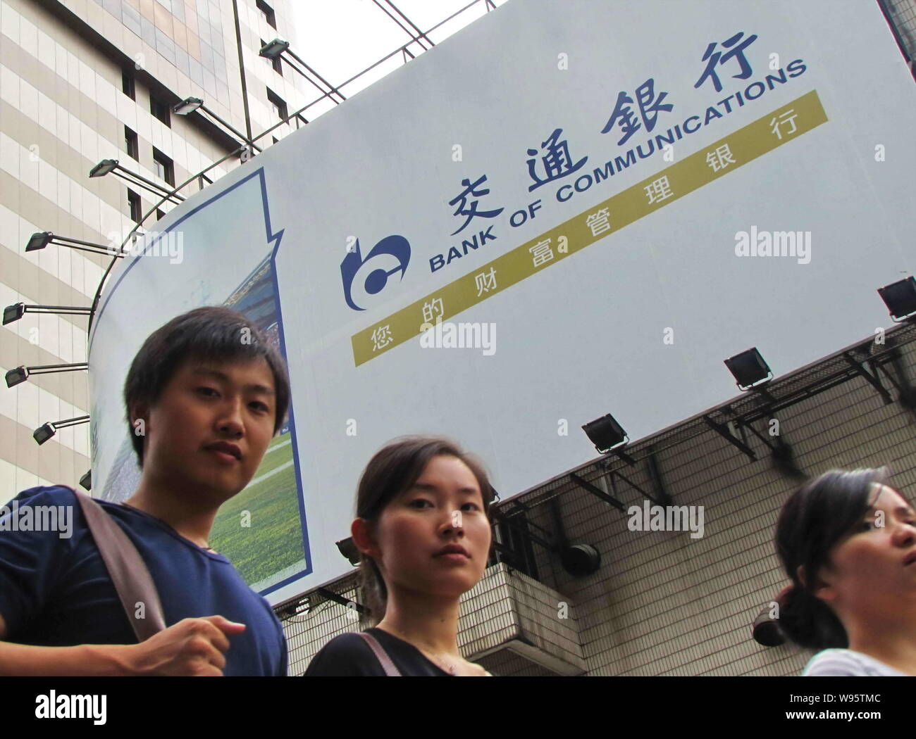 ---- Fußgänger vorbei an einer Werbung für Bank für Kommunikation (BoCom) in Shanghai, China, 27. August 2011. Bank von Communications Corp., Stockfoto