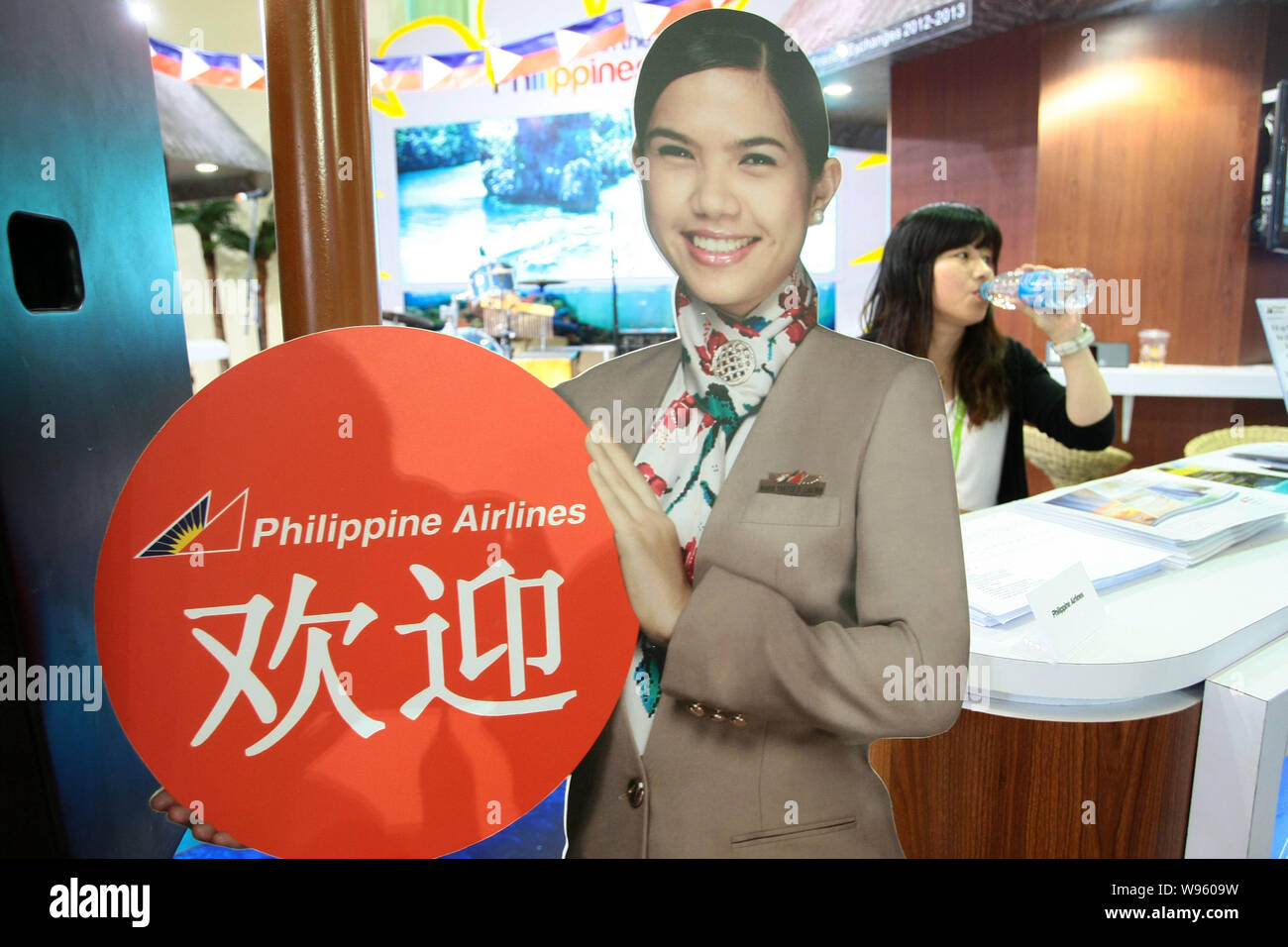 Ein Mitarbeiter der Wasser trinkt am Stand der Philippine Airlines während des 9 World Travel Fair in Shanghai, China, 11. Mai 2012. Chinesen reisen ag Stockfoto