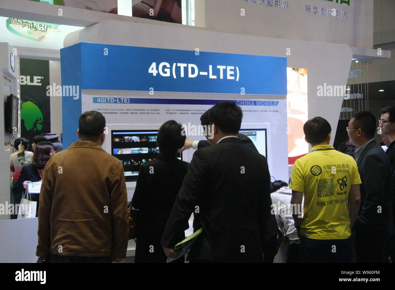 ---- Besucher sind auf dem Stand von 4 G (TD-LTE) Technologie während einer Ausstellung in Chongqing, 12. April 2012 gesehen. China wird rechtzeitig die Tria erweitern Stockfoto