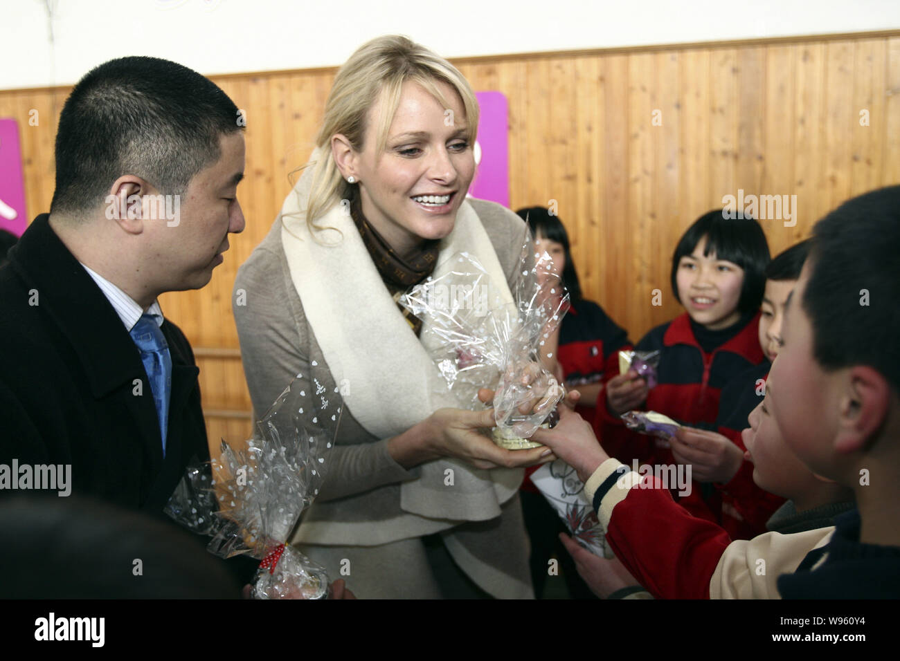 Prinzessin Charlene Wittstock von Monaco, Mitte, erhält Geschenke von jungen Studenten bei einem Besuch in der Shanghai Pudong Sonderschule in Sh Stockfoto