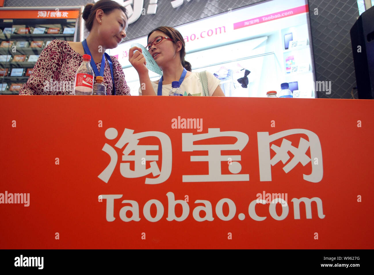 ------ Chinesische Mitarbeiter sind auf dem Stand von Taobao.com während einer Messe in Shanghai, China, 28. Juli 2011 gesehen. Eine Reihe von Mitarbeitern, die an Taobao, China la Stockfoto