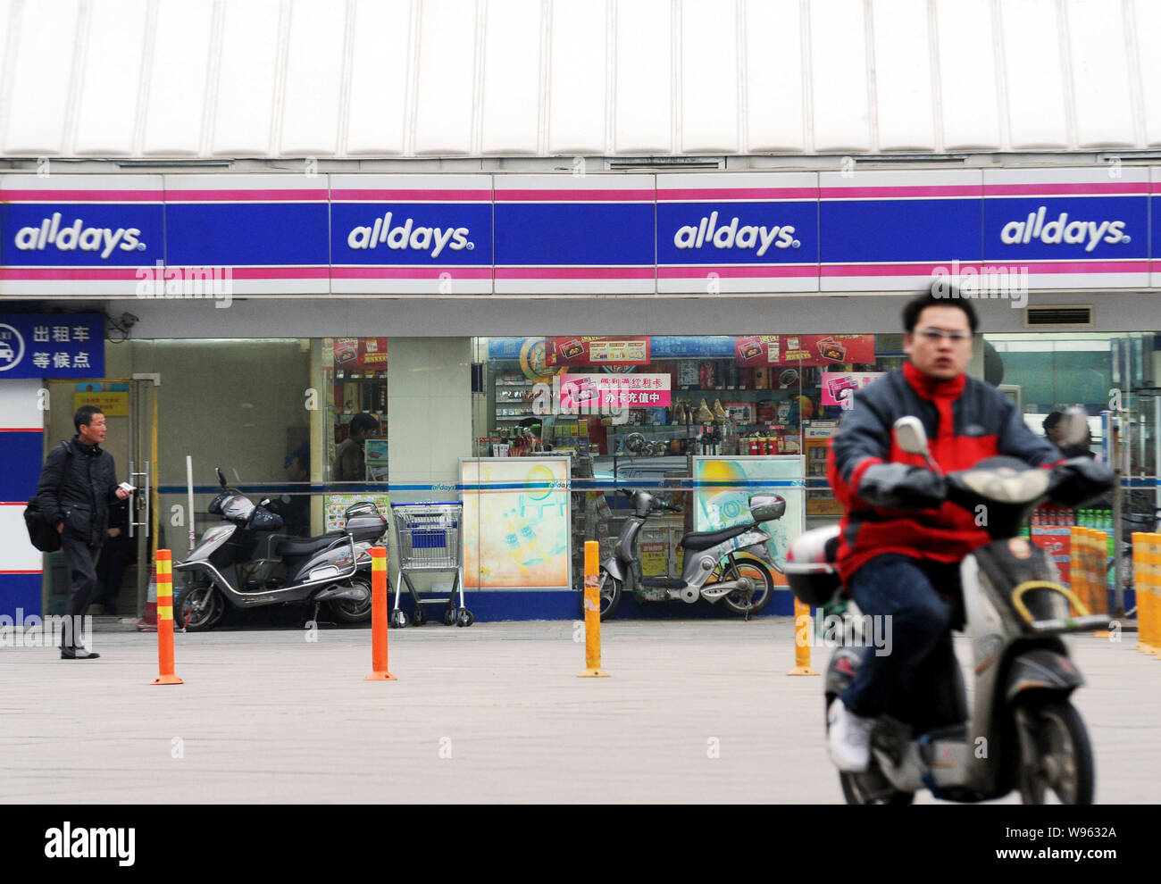 ---- Ein Radfahrer vorbei eine Alldays Convenience Store in Shanghai, China, 14. März 2011. Die Shanghai Niederlassung von China Life Insurance (Gruppe) Komp Stockfoto