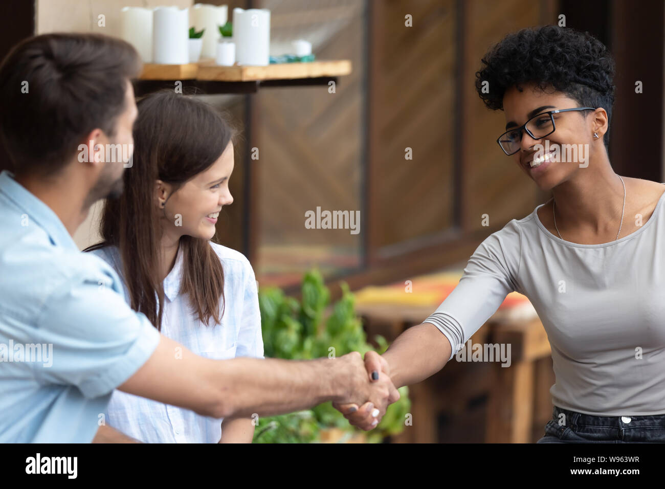 Glückliches Paar handshake weiblichen Spezialist bei der Konferenz Stockfoto