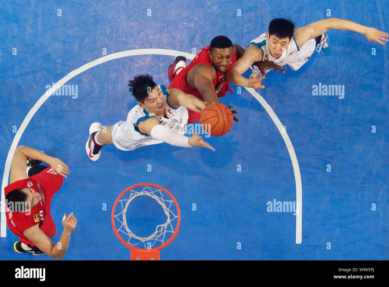K. Mbenga der Qingdao Adler, zweite rechts,, Herausforderungen Spieler der Fujian Störe in ihrer ersten Runde während des 2012/2013 CBA seaso Stockfoto