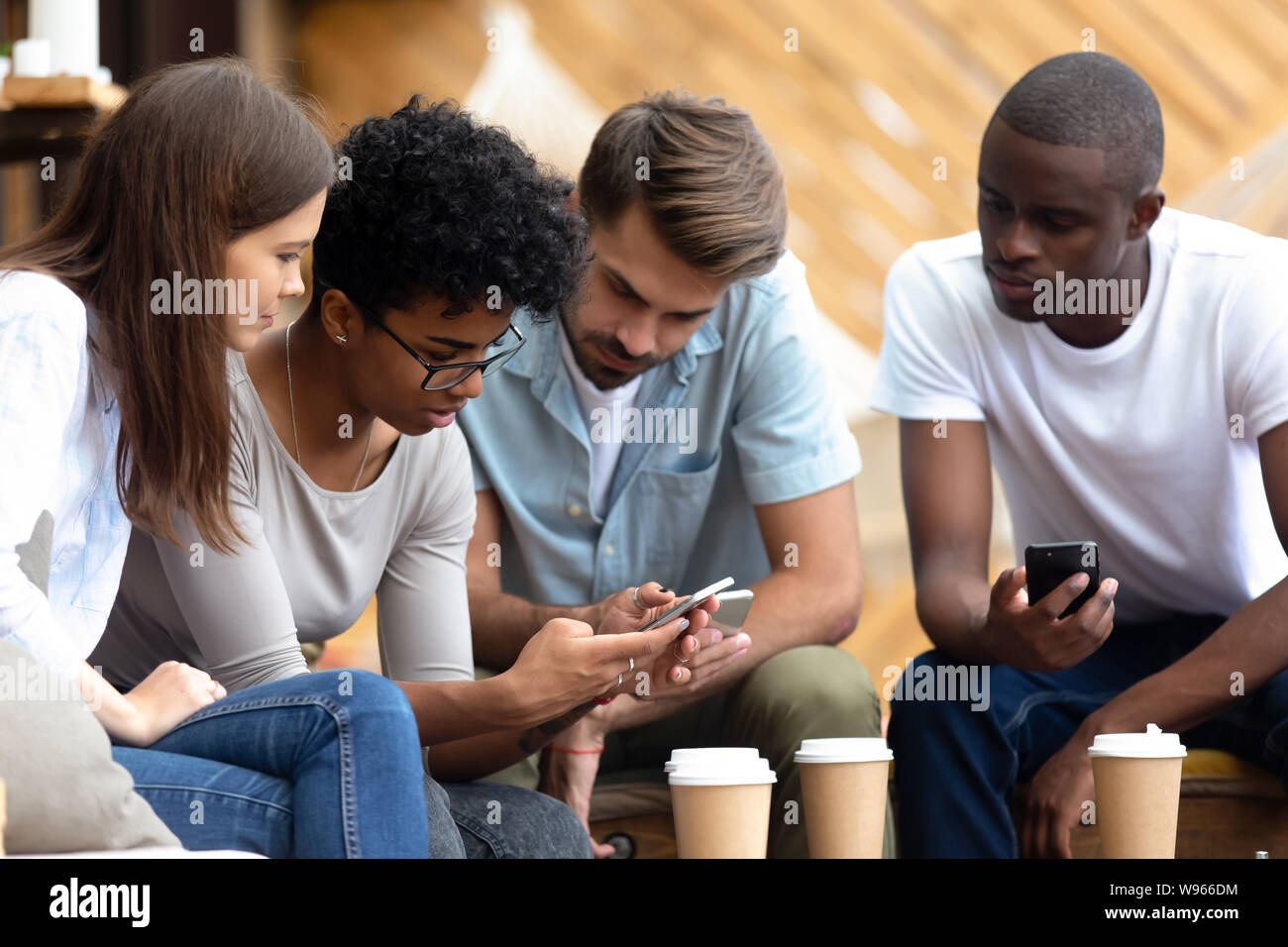 Die jungen Menschen besetzt mit Smartphones zusammen Diverse Stockfoto