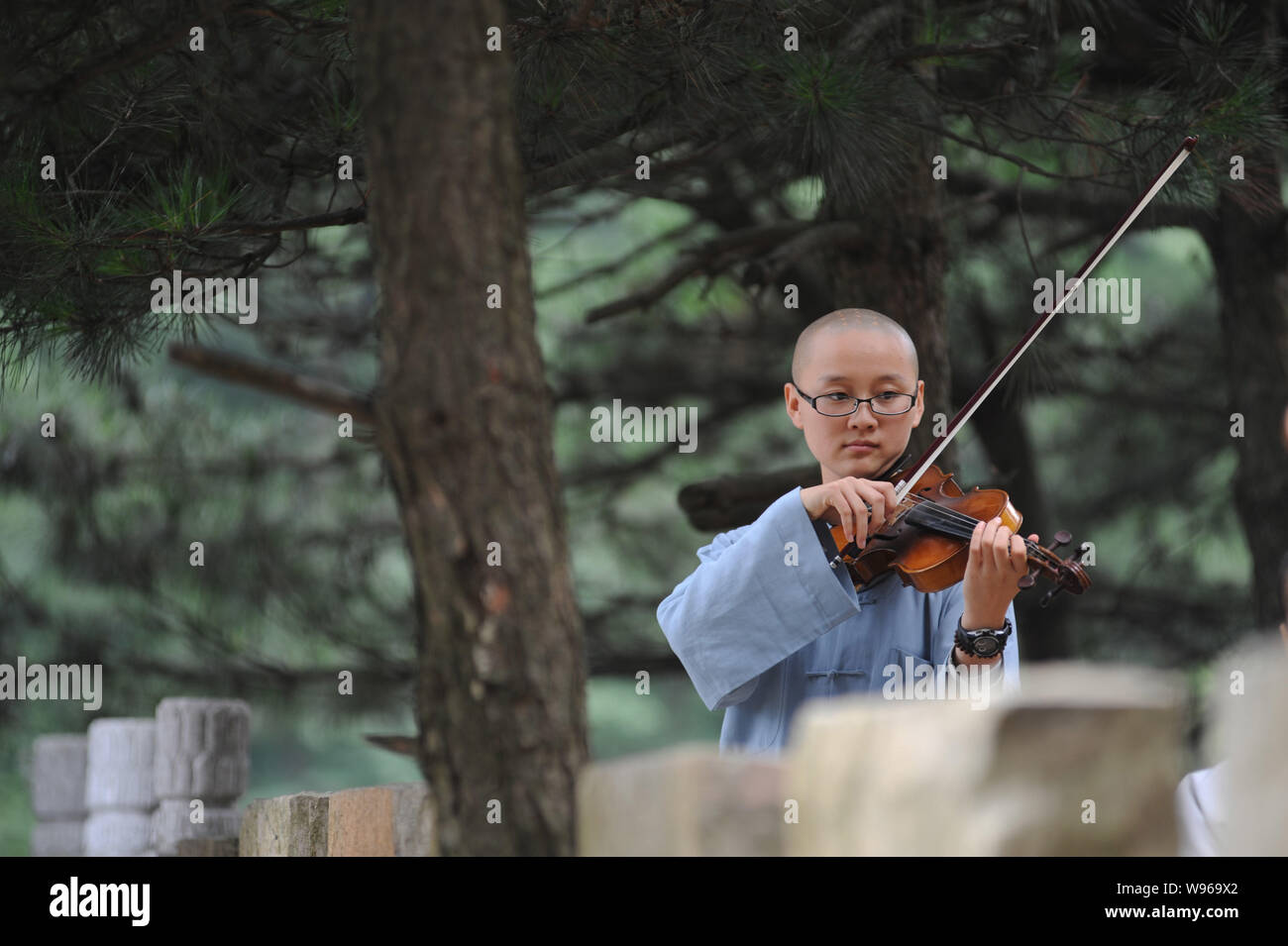 Einem chinesischen buddhistischen Nonne von Guangxuan Kunst Truppe Praktiken spielen Violine während einer Schulung bei Tiantai Tempel auf Berg Tiantai HongAn zählen Stockfoto