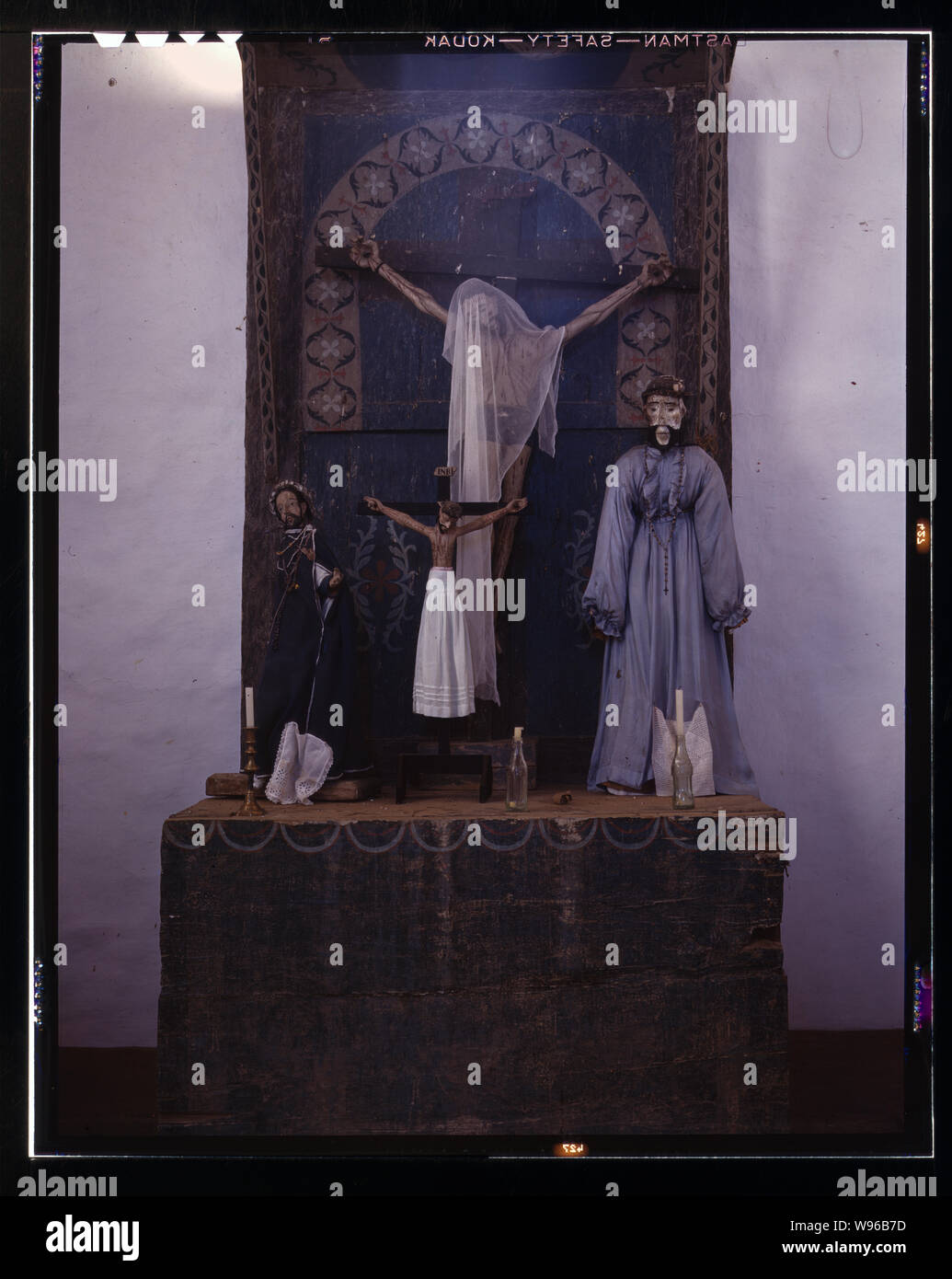 Altar in der Kirche, Trampas, New Mexico. Die vorherrschenden Farben sind grau und blau. Eine Coca-Cola-Flasche dient als Kerzenhalter Stockfoto