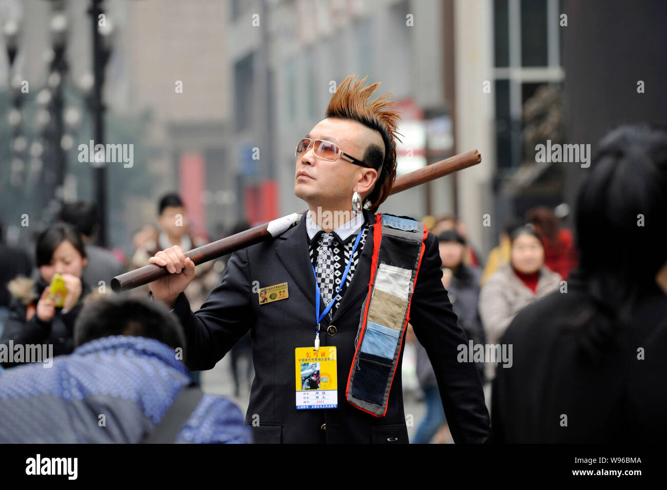 Zhou Fei, wie die Angesagtesten Bettler in China bekannt ist, stellt in einer Fußgängerzone in Chongqing, China, 23. Februar 2012. Anzug, gespritzt Stockfoto