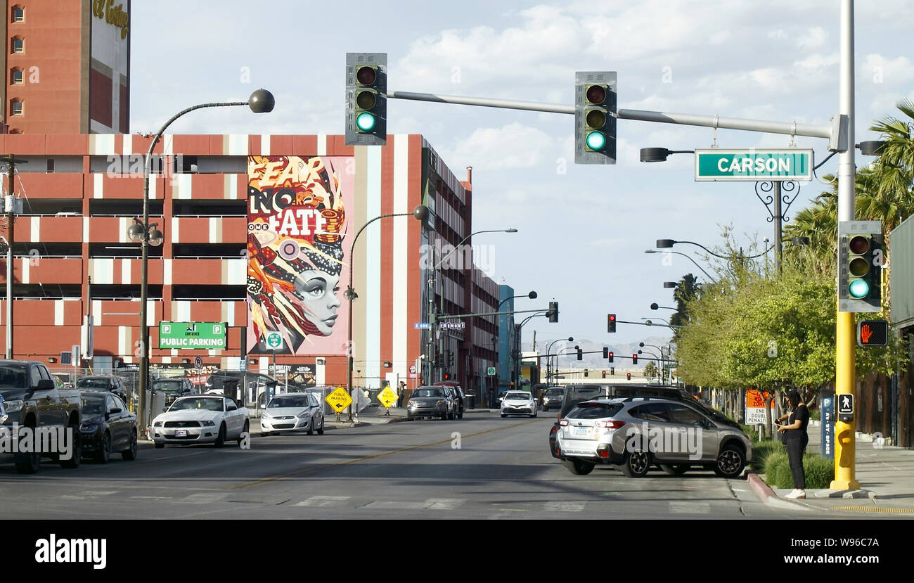 Las Vegas Downtown mit Straßenlaternen und Kreuzungen, ein Wandbild mit Show Girl Graffiti Design im Vordergrund, die das Gefühl der unwirklichen Welt am besten. Stockfoto