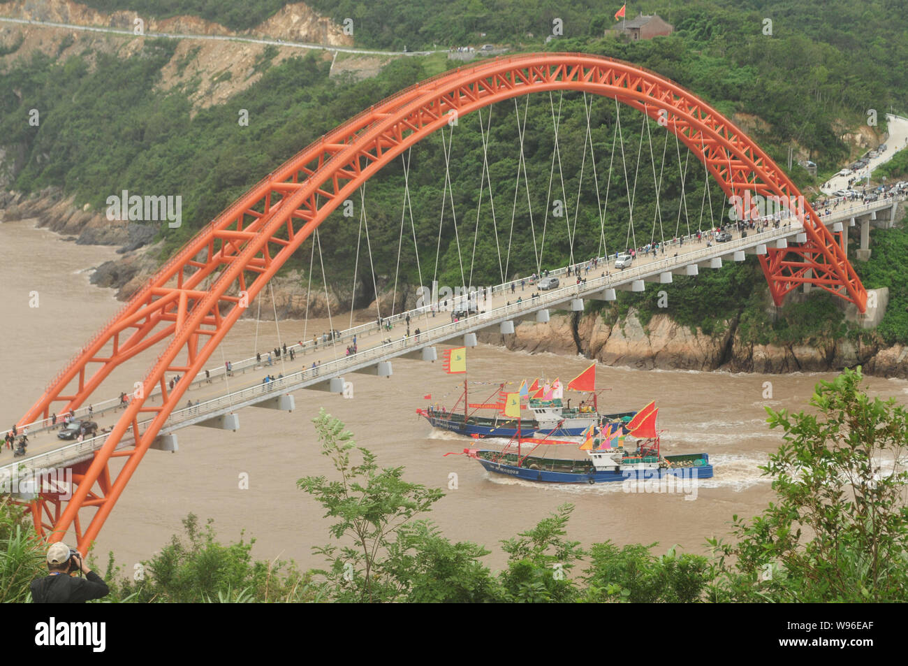 Fischerboote fahren Sie unter die Brücke, als sie aus einem Hafen von Shipu Stadt segeln, Xiangshan County, Ningbo City, East China, 16. September 2012. Die summ Stockfoto