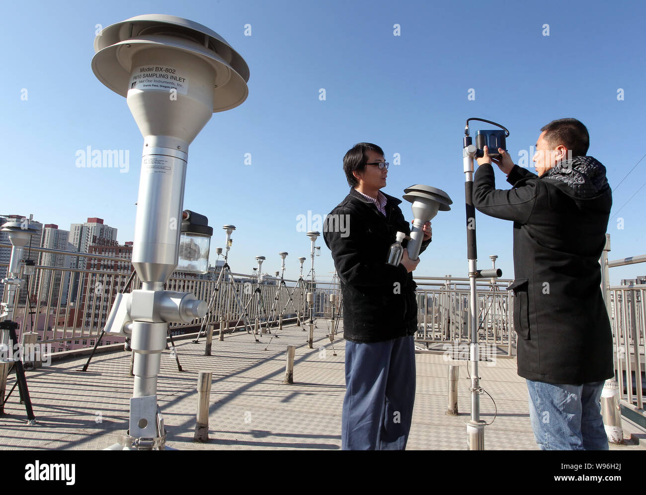 Chinesische Umweltüberwachung Arbeiter Gerät installieren zu PM2,5 (Feinstaub bis 2,5 Mikrometer im Durchmesser) auf einer Überwachungsstation erkennen Stockfoto