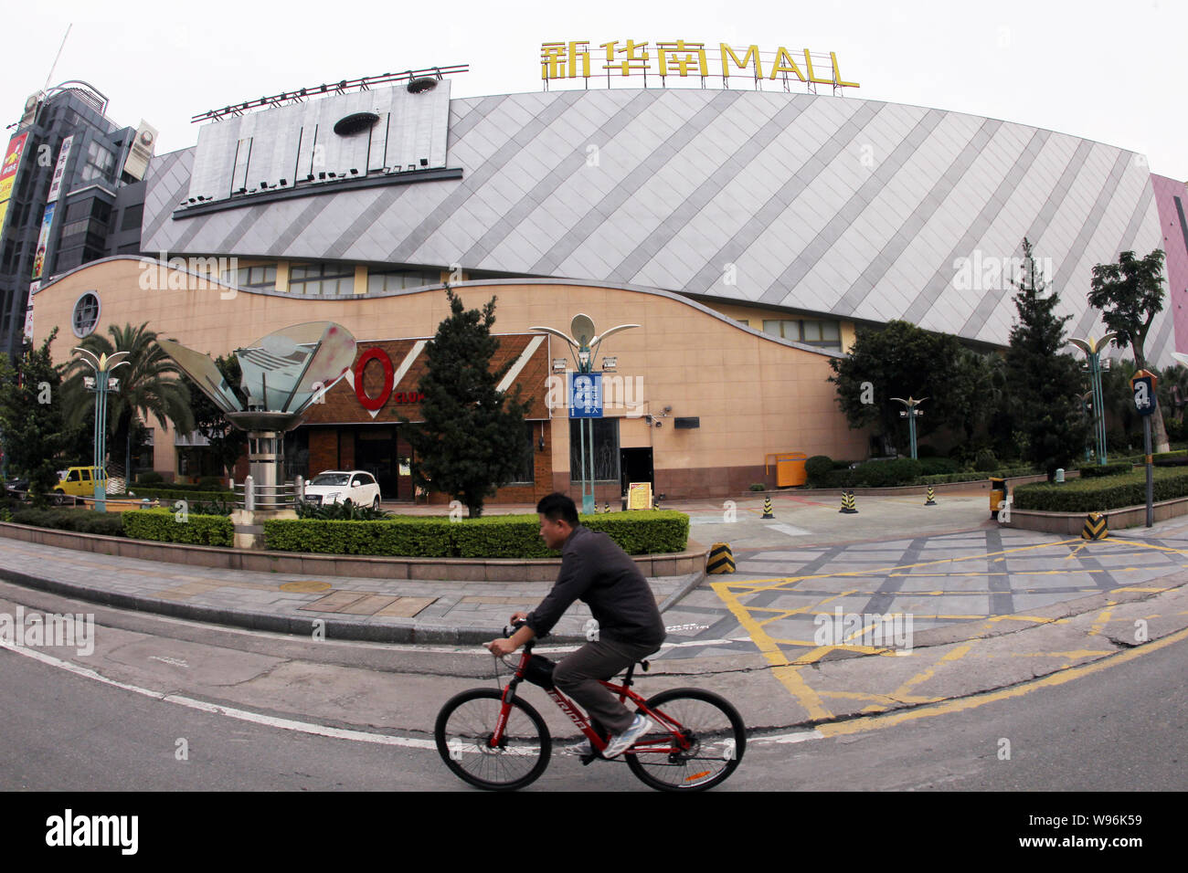Ein Mann fährt mit dem Fahrrad hinter dem neuen South China Mall in Dongguan City, South China Guangdong Provinz, 9. April 2012. Die neuen South China Mall in Donggu Stockfoto