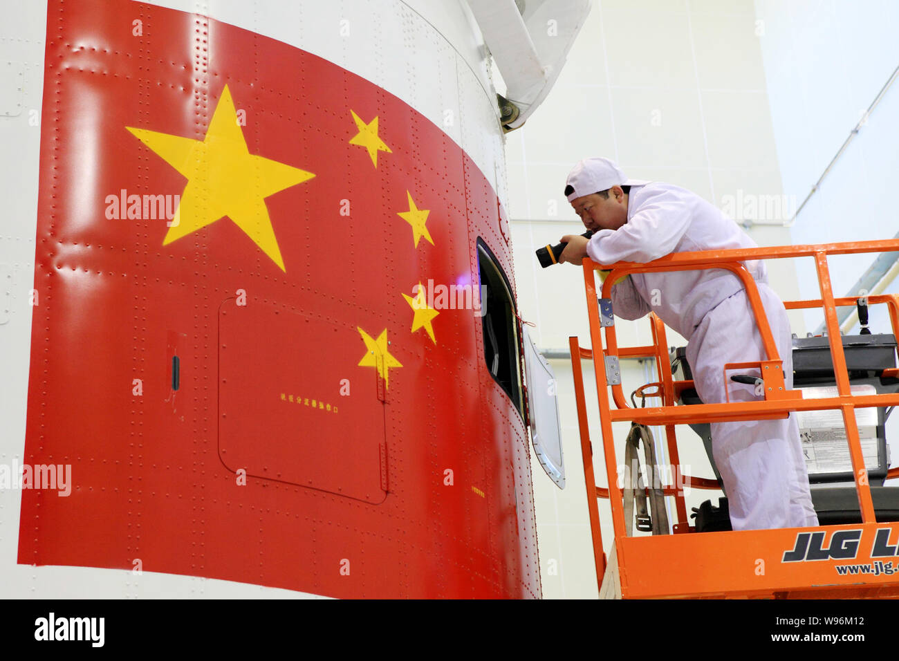 Eine chinesische Luft- und Raumfahrt Ingenieur überprüft die Verkleidung des Shenzhou Shenzhou-9 (IX) Satelliten im Jiuquan Satellite Launch Center in der Nähe von jiuquan Stadt, n Stockfoto