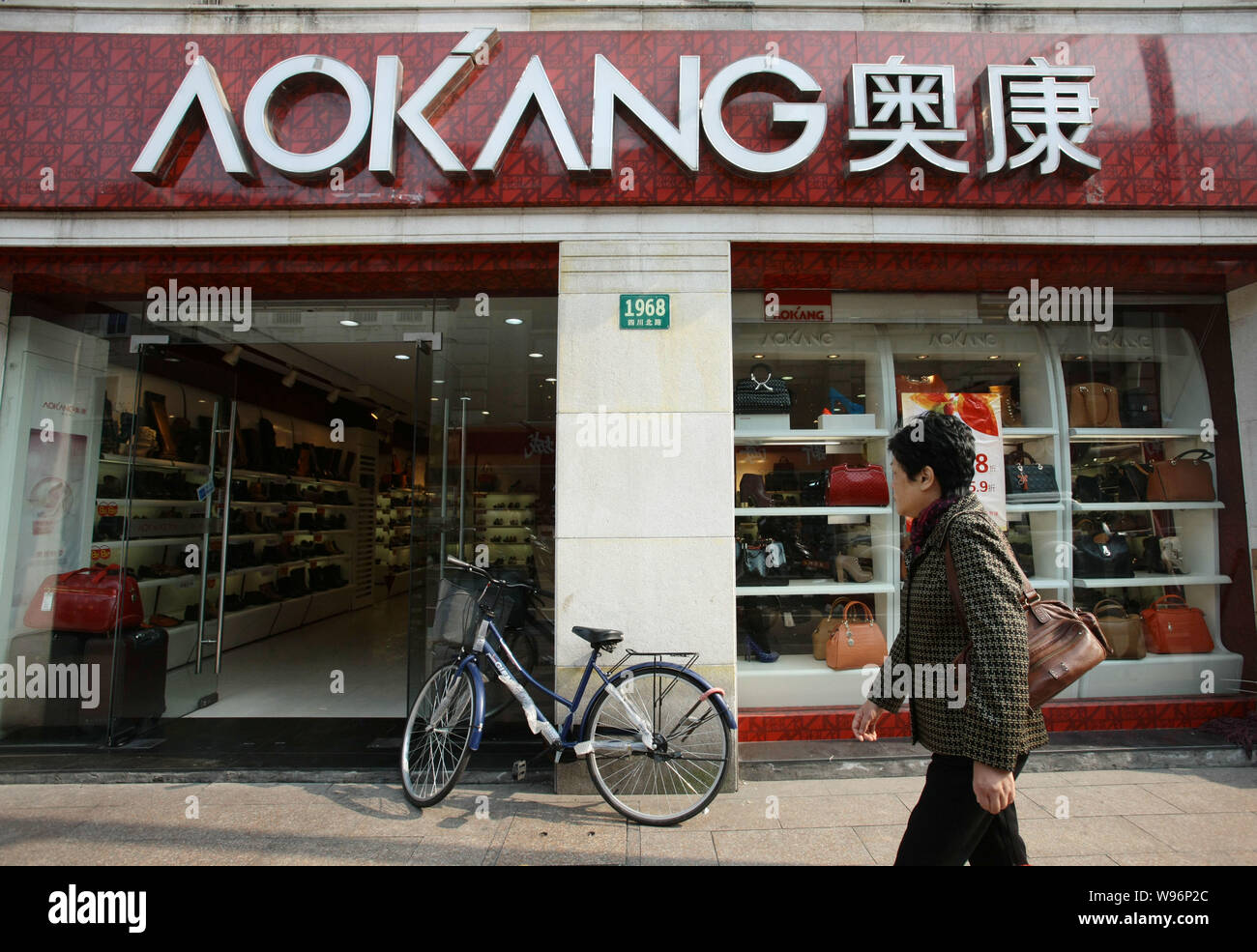 Ein Fußgänger geht vorbei an einem Aokang Schuhgeschäft in Shanghai, China, 19. November 2012. Durch das Gewinnen von einem Prozeß am Sonntag (18. November 2012) gegen die Eur Stockfoto