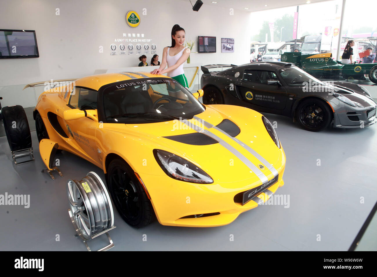 Ein Modell wirft mit einem Lotus NYO Elise roadster während der 12. Internationalen Automobil Ausstellung, als "Auto China 2012" in Peking, China Stockfoto