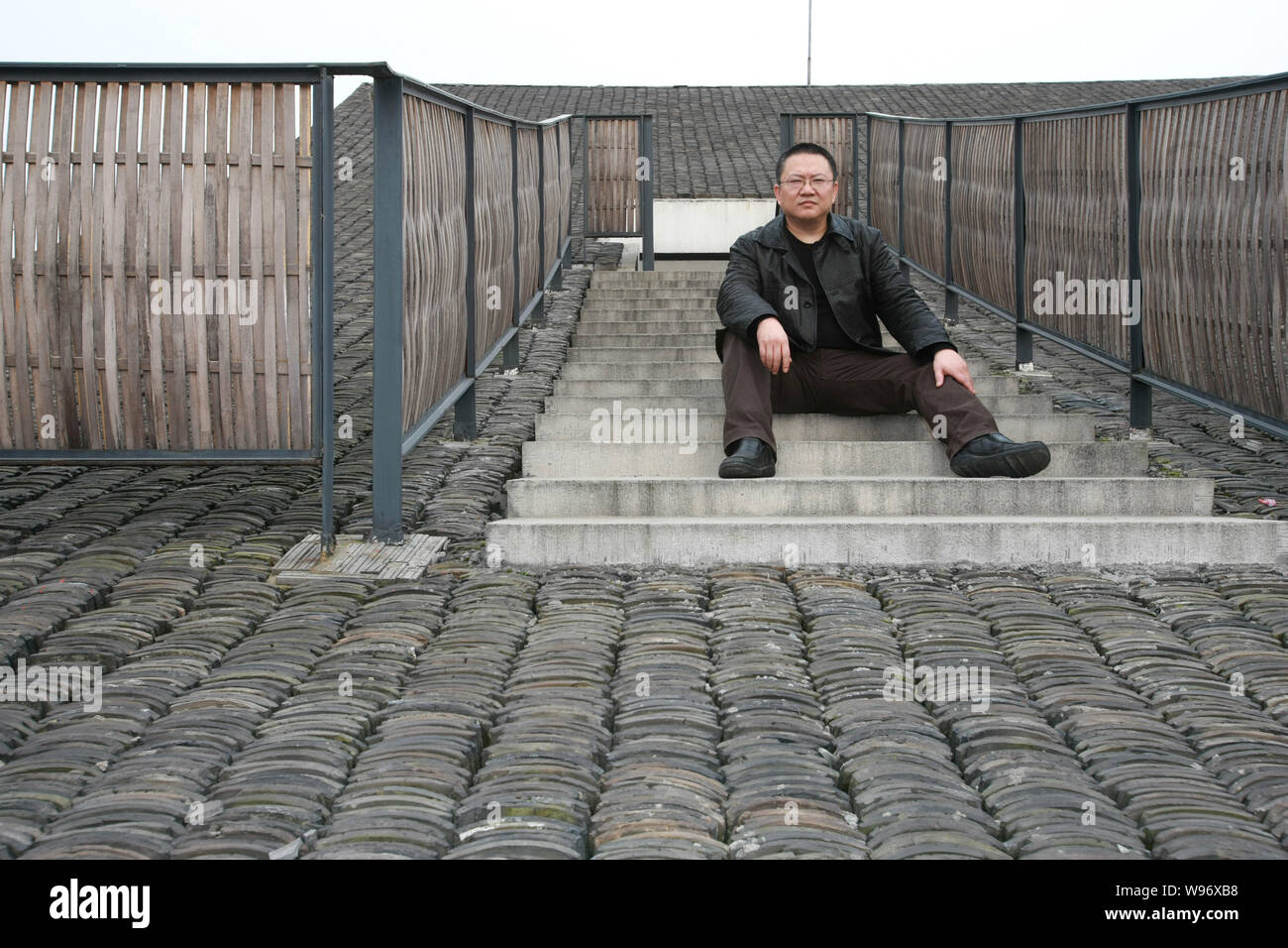 ---- Chinese Architektin Wang Shu, Inhaber der laienhaften Architektur Studio, stellt auf dem Dach einer Architektur, die er an der Xiangshan Campus konzipiert Stockfoto