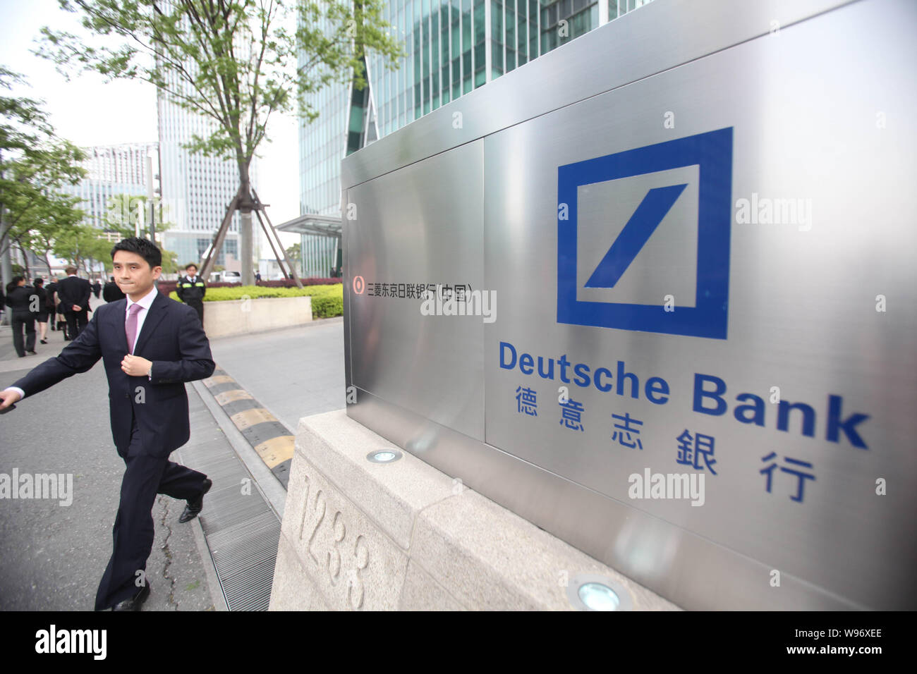 ---- Eine chinesische Spaziergänge hinter dem Logo der Deutsche Bank in Shanghai, China, 18. April 2011. Die Nationale Kommission für Entwicklung und Reform hat angesprochen Stockfoto